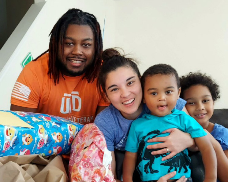 Student veteran Jeff Wilson smiling for a picture with his wife and two children