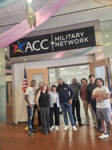 Group of people standing under a banner that reads "ACC Military Network"